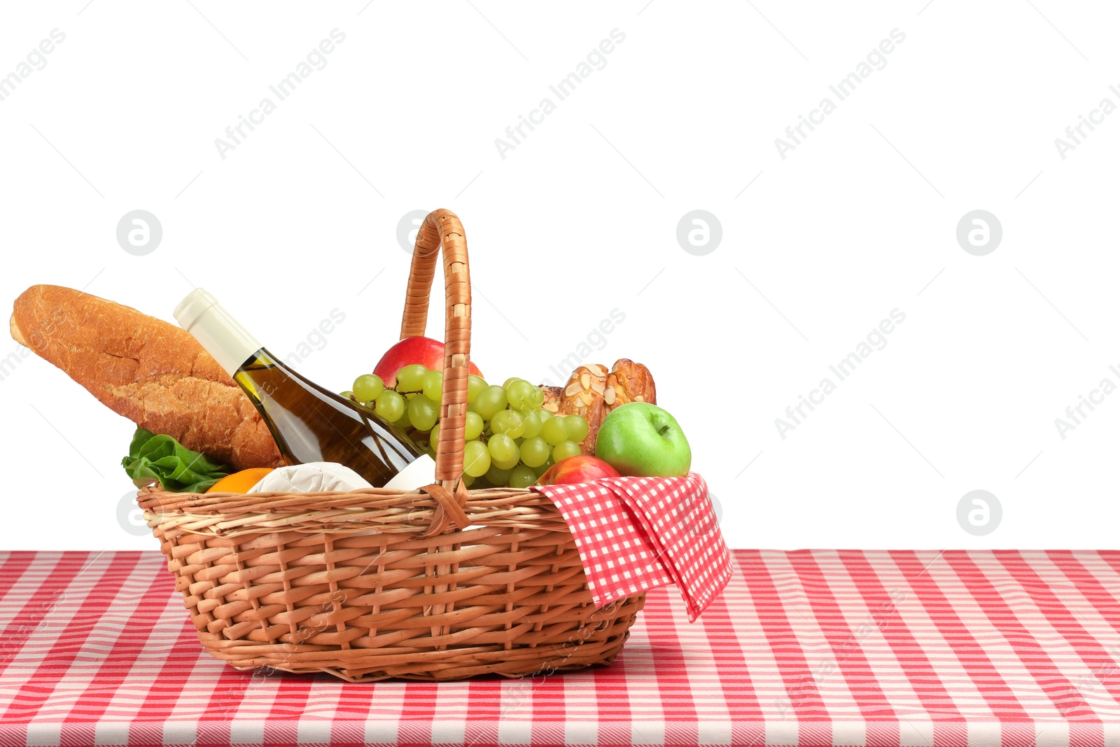 Photo of Picnic wicker basket with food, bottle of wine and napkin on table against white background. Space for text