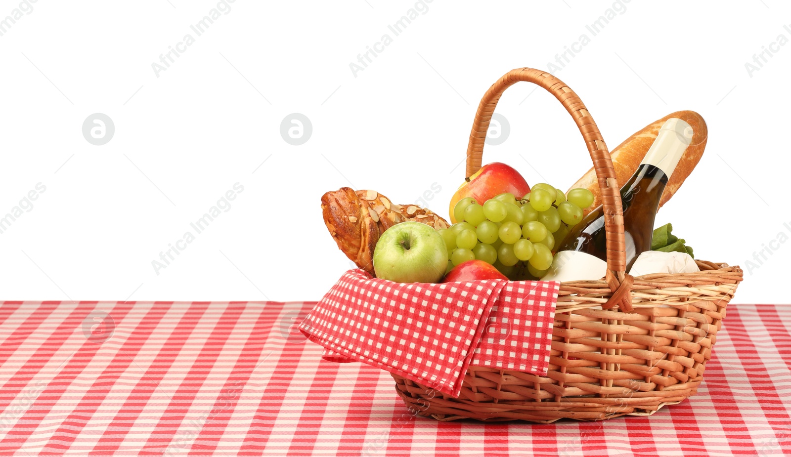 Photo of Picnic wicker basket with food, bottle of wine and napkin on table against white background. Space for text