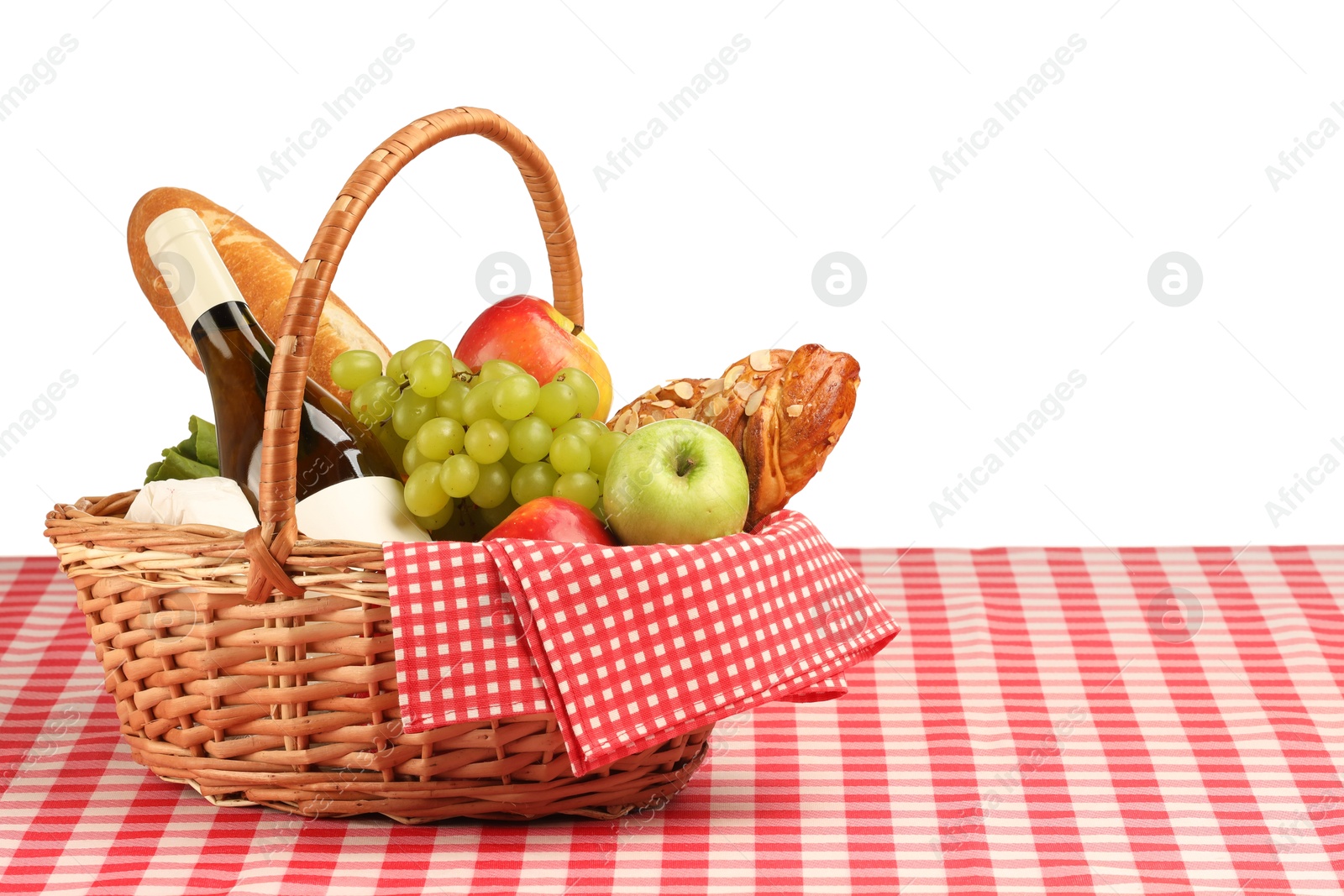 Photo of Picnic wicker basket with food, bottle of wine and napkin on table against white background. Space for text