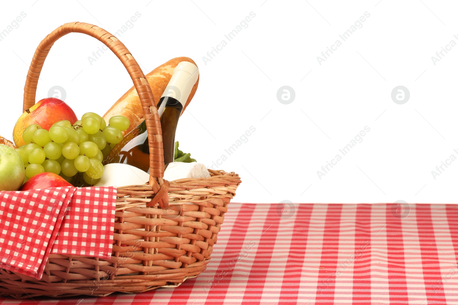 Photo of Picnic wicker basket with food, bottle of wine and napkin on table against white background. Space for text