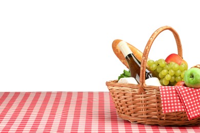 Photo of Picnic wicker basket with food, bottle of wine and napkin on table against white background. Space for text