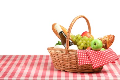 Photo of Picnic wicker basket with food, bottle of wine and napkin on table against white background. Space for text