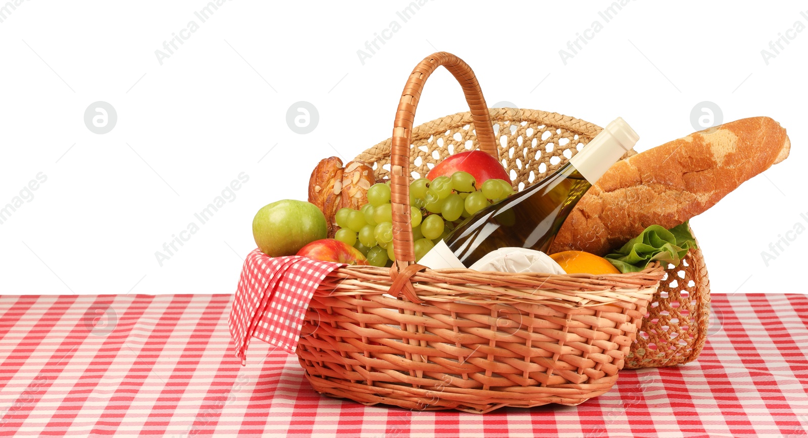 Photo of Picnic wicker basket with food, bottle of wine and napkin on table against white background. Space for text