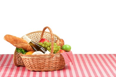 Photo of Picnic wicker basket with food, bottle of wine and napkin on table against white background. Space for text