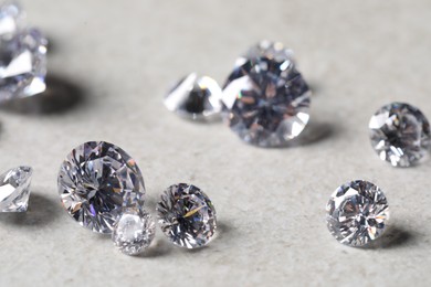 Photo of Many beautiful shiny diamonds on light background, closeup