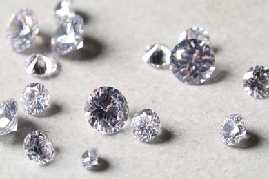 Photo of Many beautiful shiny diamonds on light background, closeup