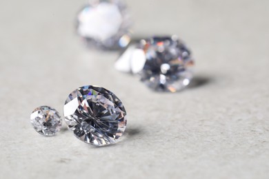 Many beautiful shiny diamonds on light background, closeup