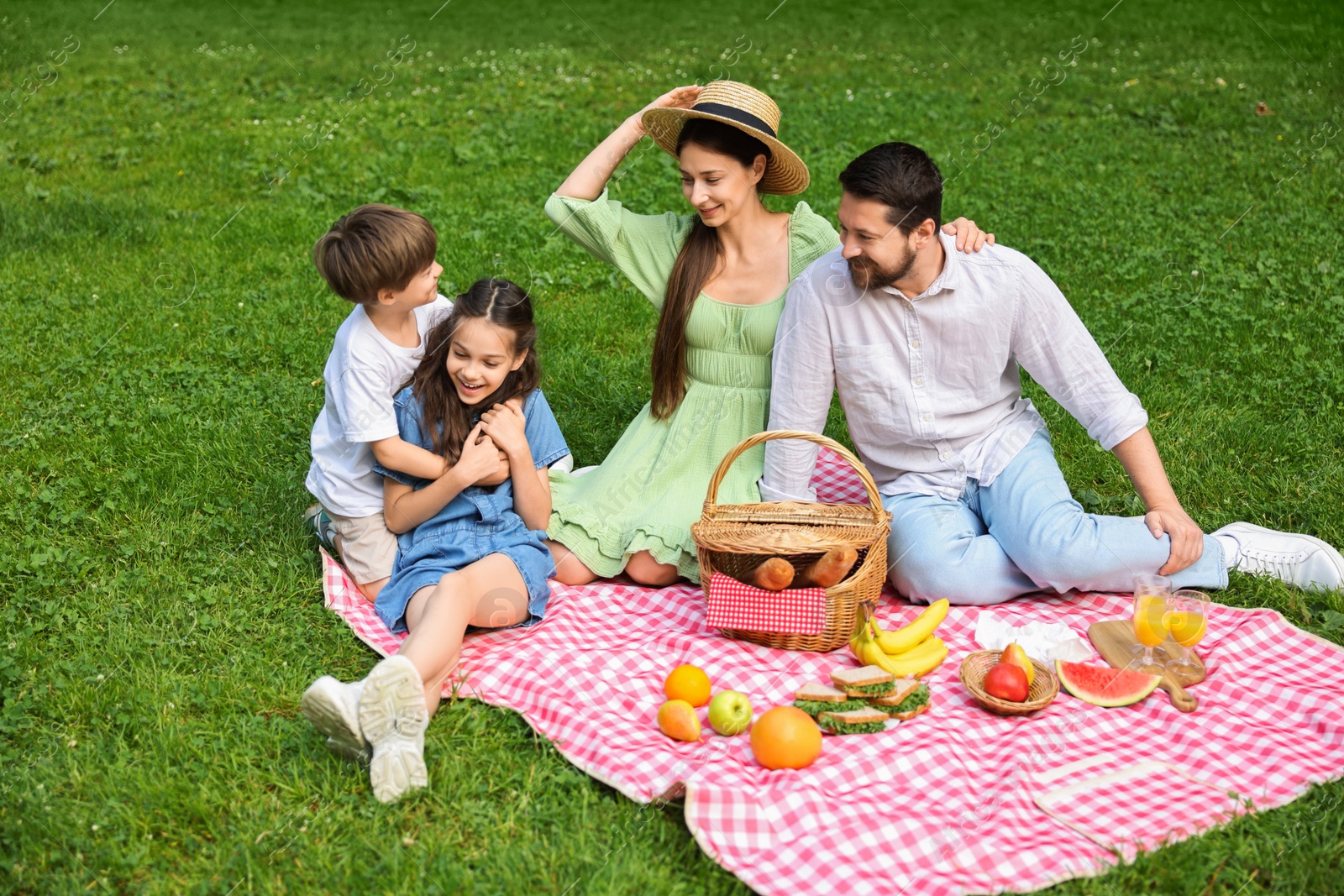 Photo of Happy family having picnic together in park