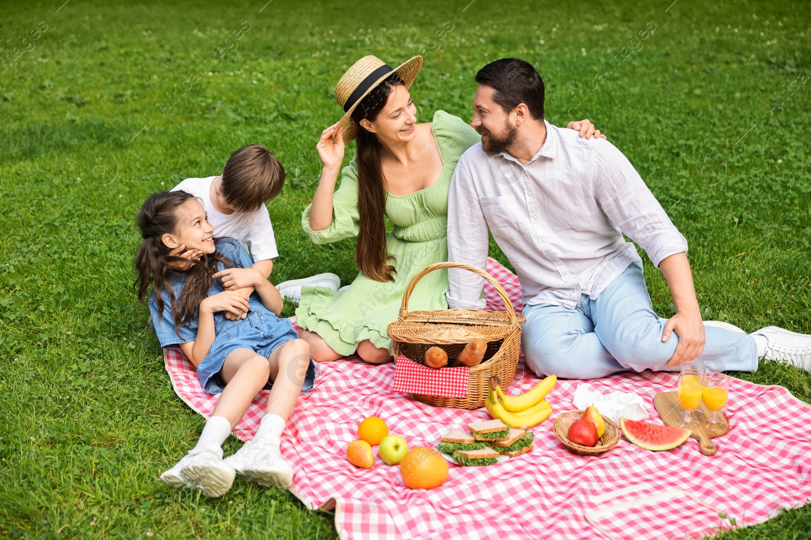 Photo of Happy family having picnic together in park