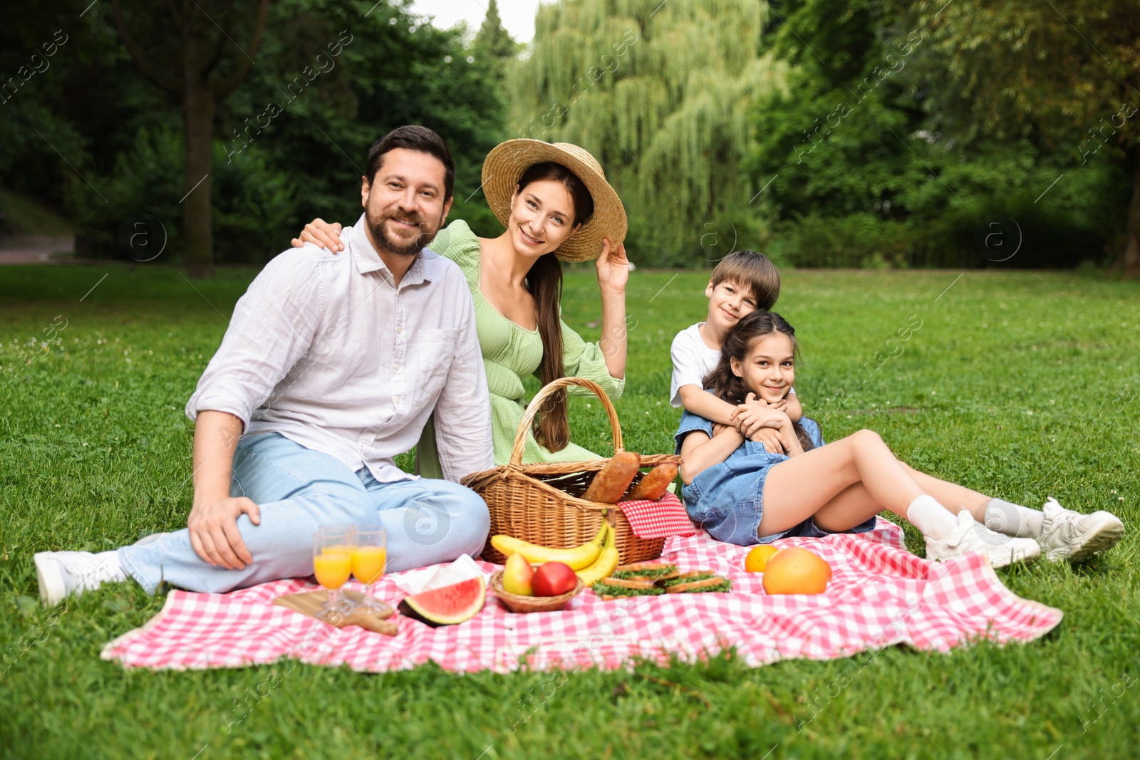 Photo of Happy family having picnic together in park