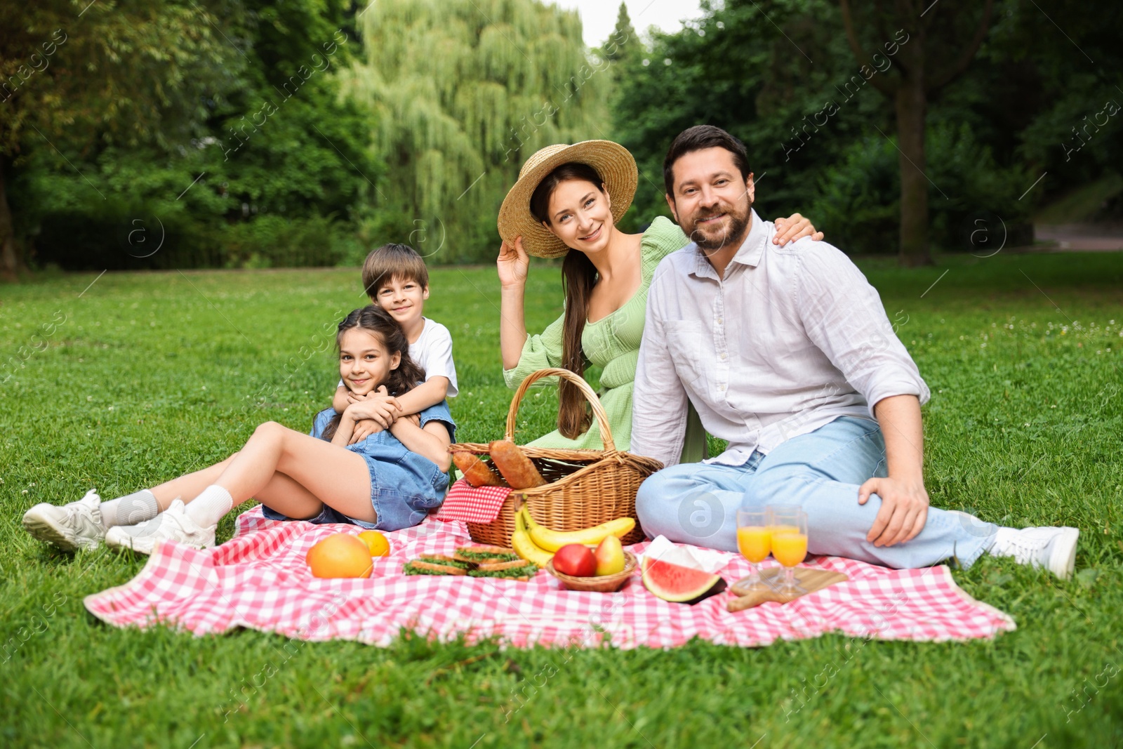 Photo of Happy family having picnic together in park