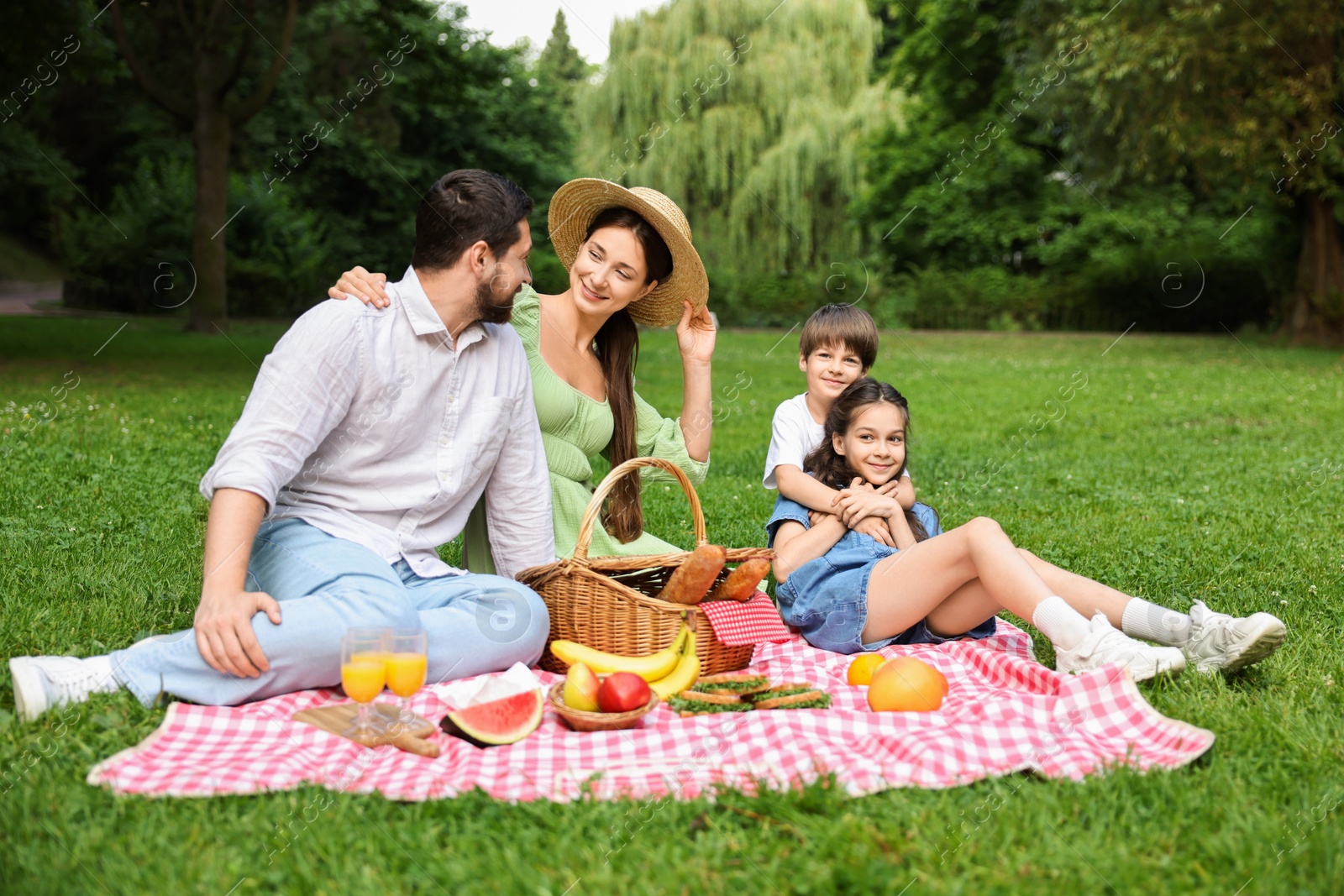 Photo of Happy family having picnic together in park