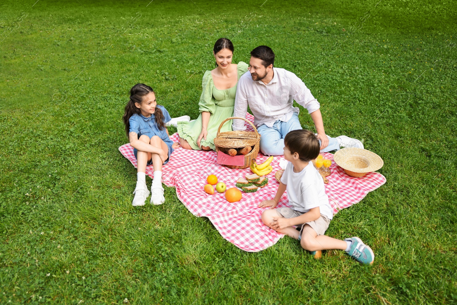 Photo of Happy family having picnic together in park