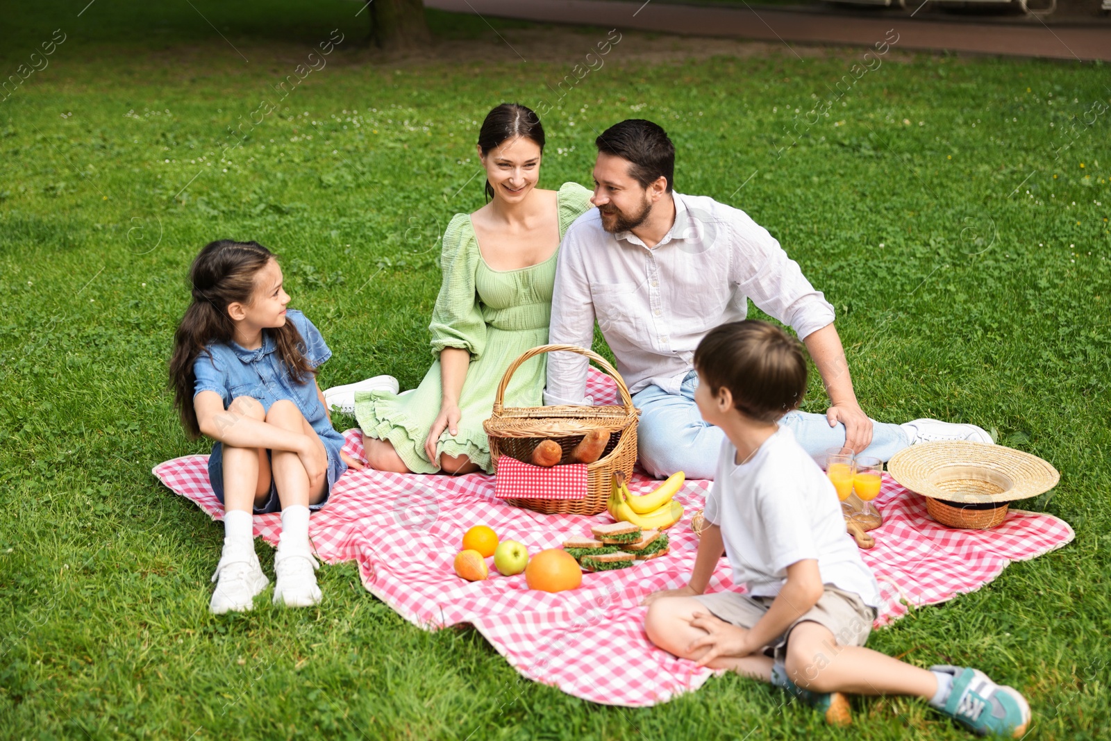 Photo of Happy family having picnic together in park