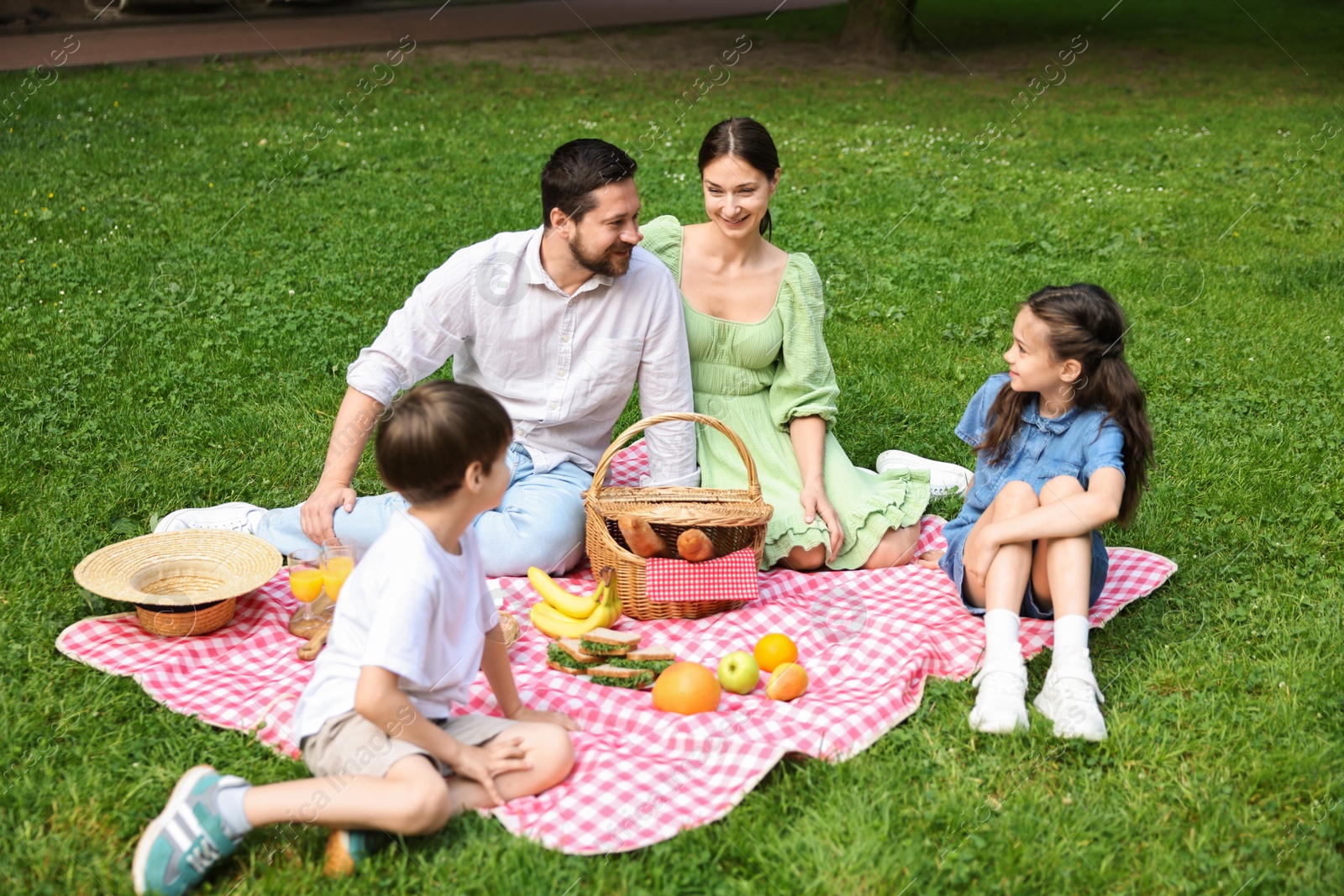 Photo of Happy family having picnic together in park