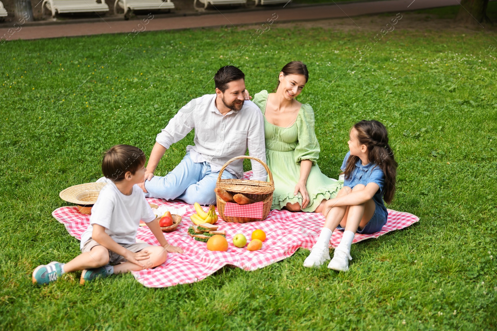 Photo of Happy family having picnic together in park