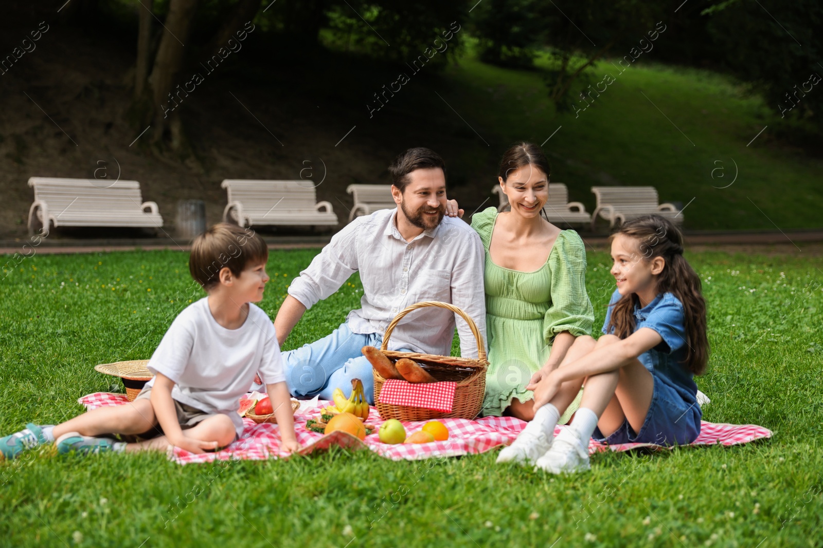 Photo of Happy family having picnic together in park