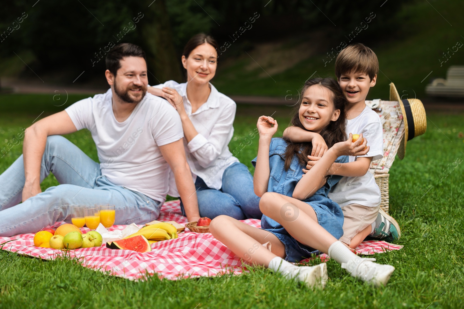 Photo of Happy family having picnic together in park