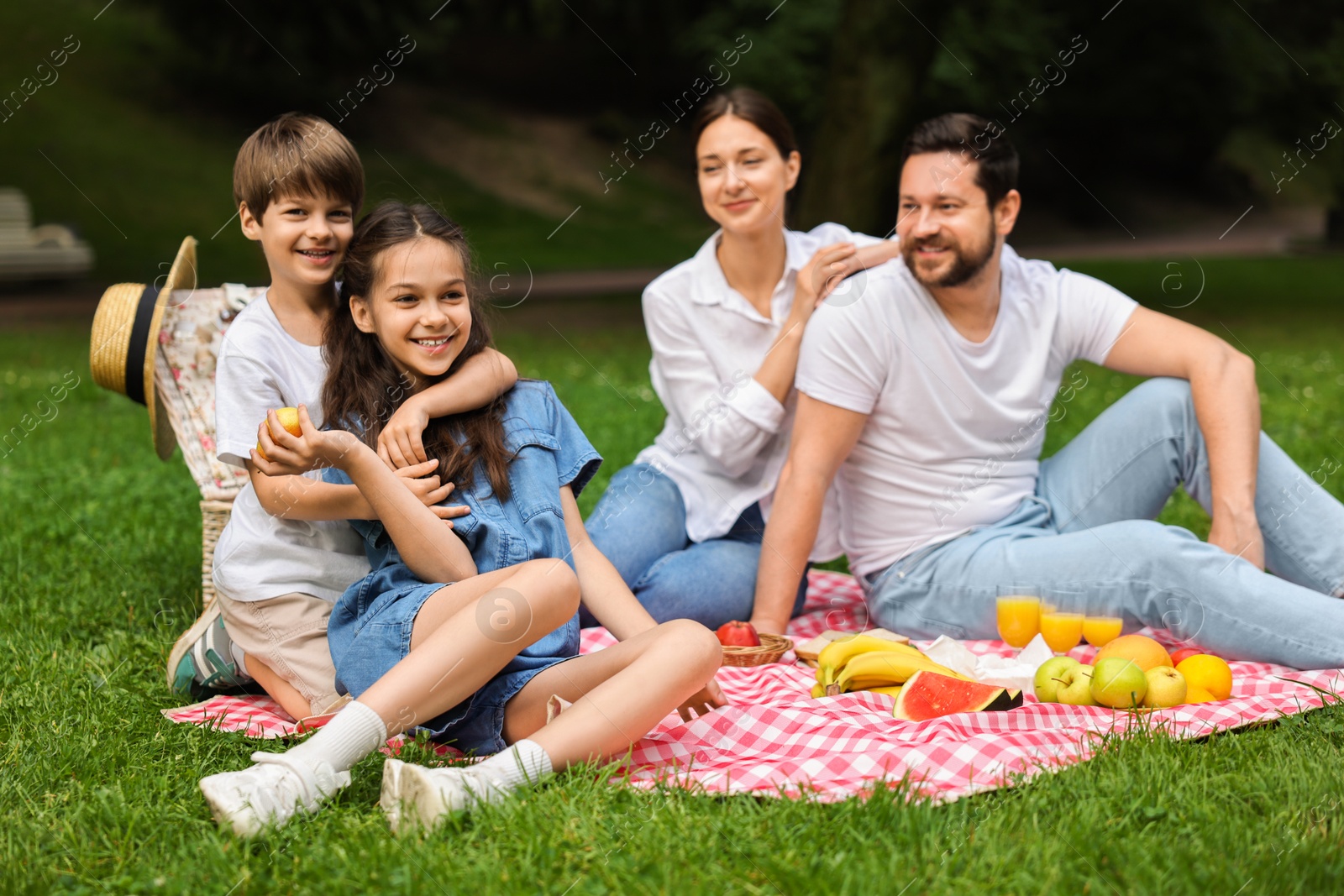 Photo of Happy family having picnic together in park