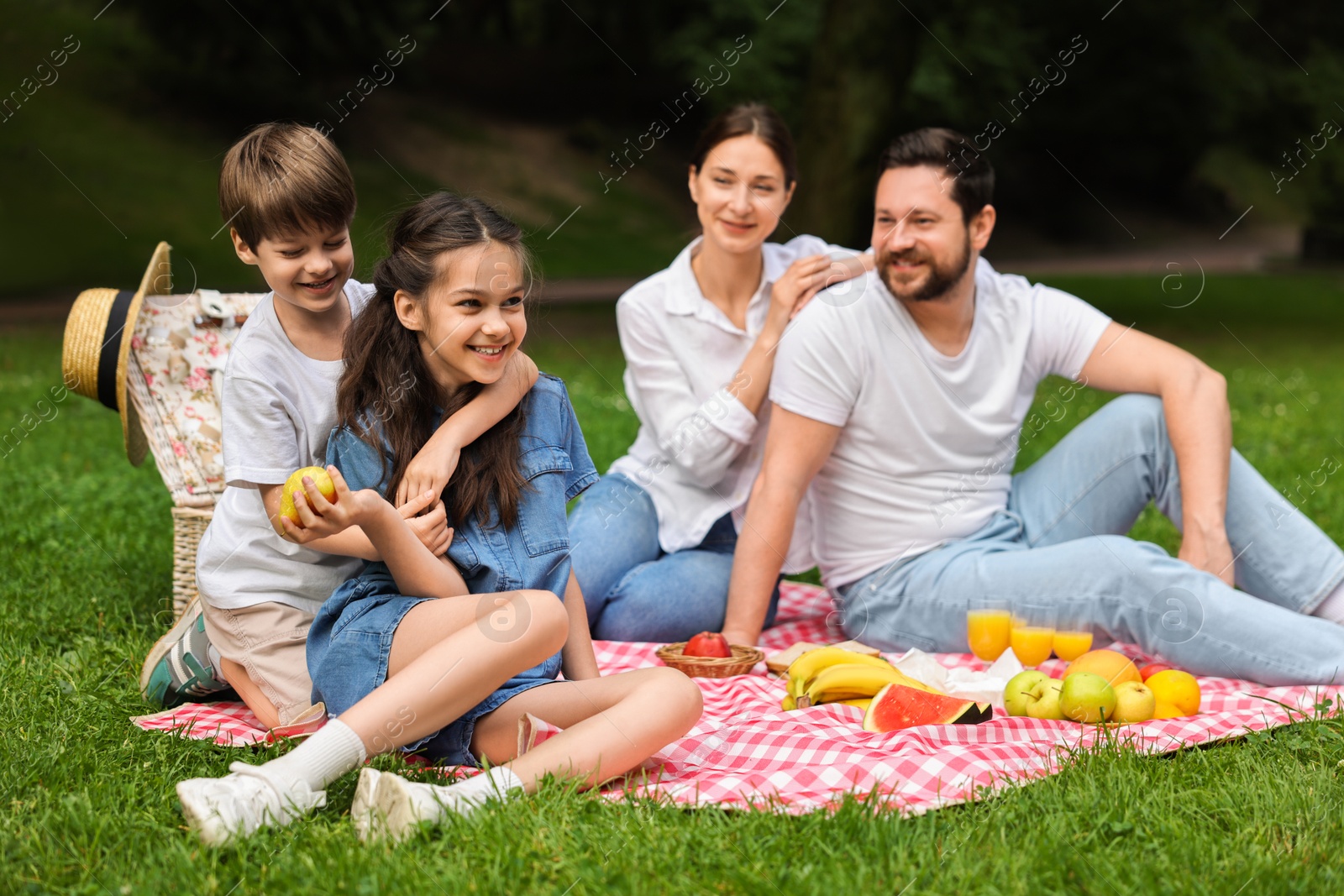 Photo of Happy family having picnic together in park