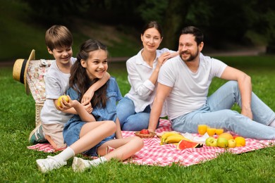 Photo of Happy family having picnic together in park
