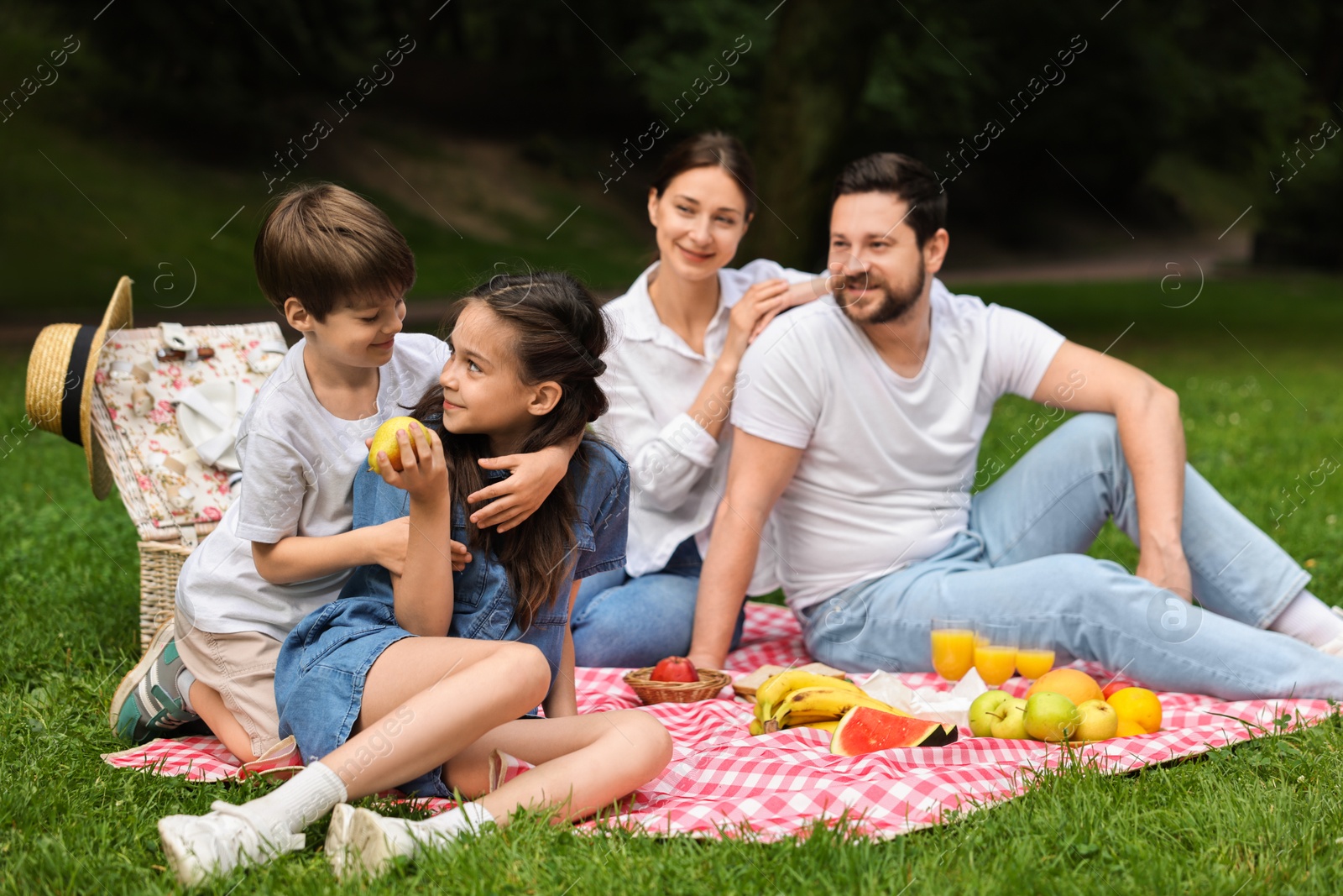 Photo of Family picnic. Parents and their children spending time together outdoors