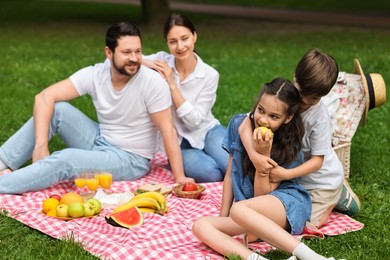 Photo of Family picnic. Parents and their children spending time together outdoors