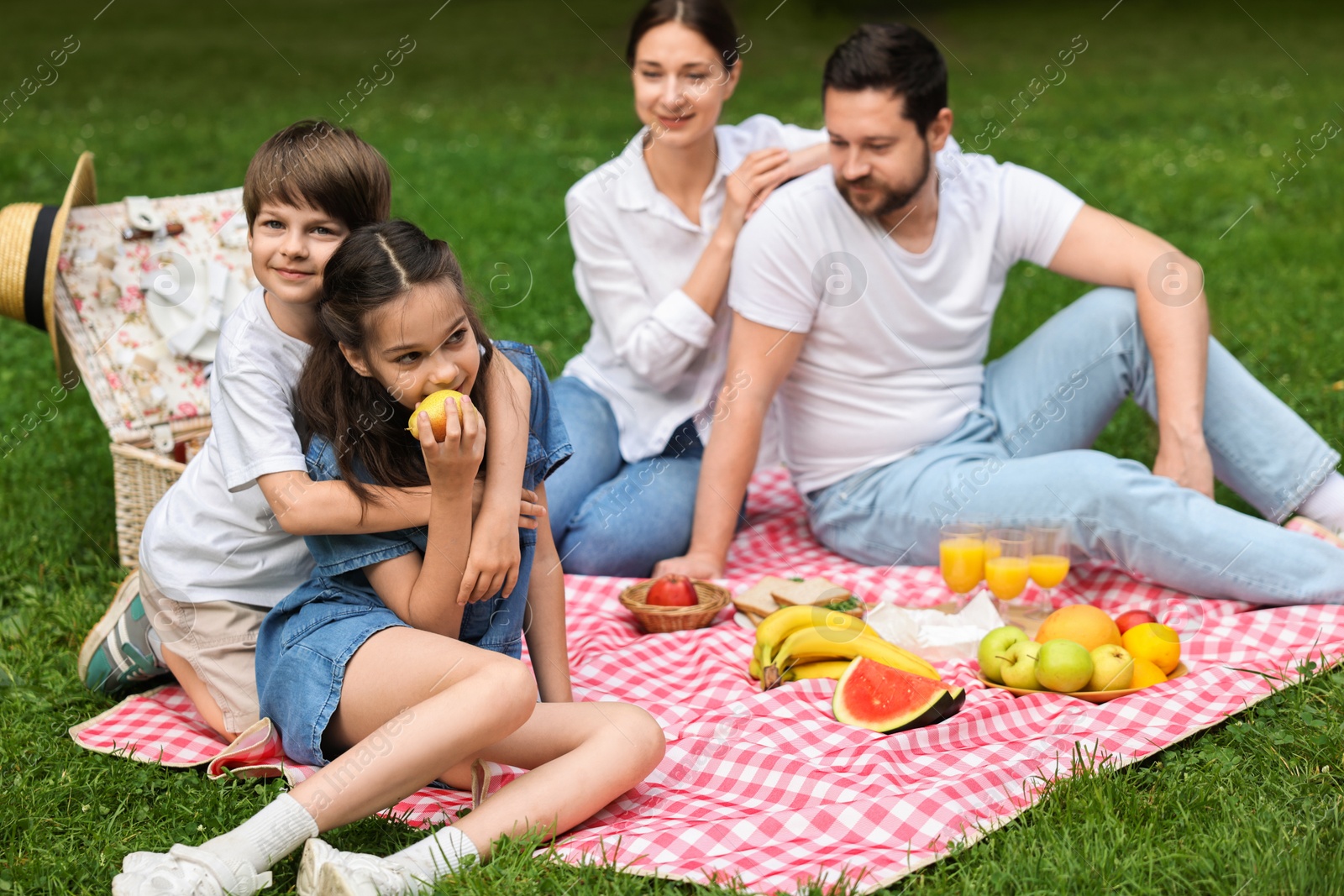 Photo of Family picnic. Parents and their children spending time together outdoors