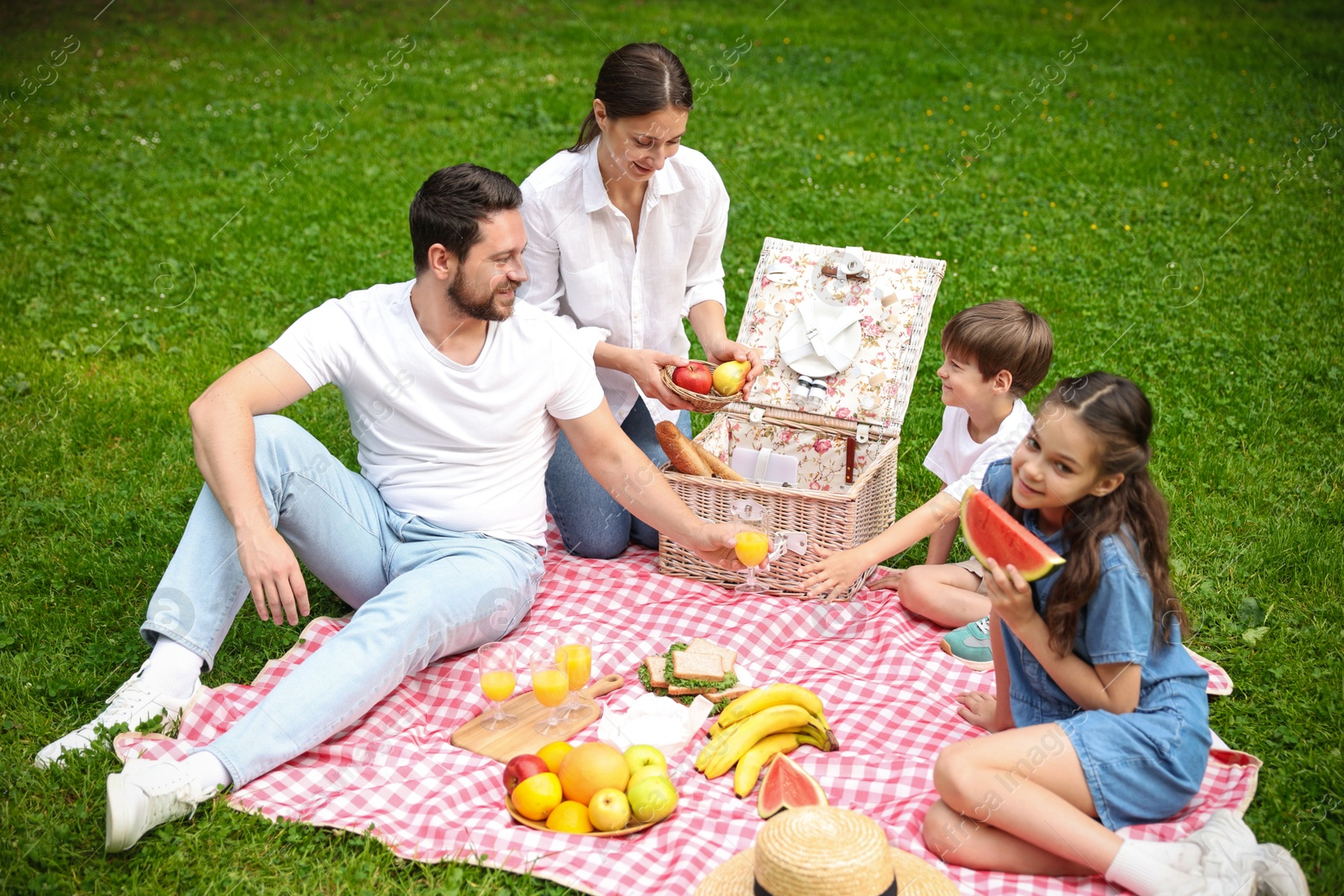 Photo of Happy family having picnic together in park