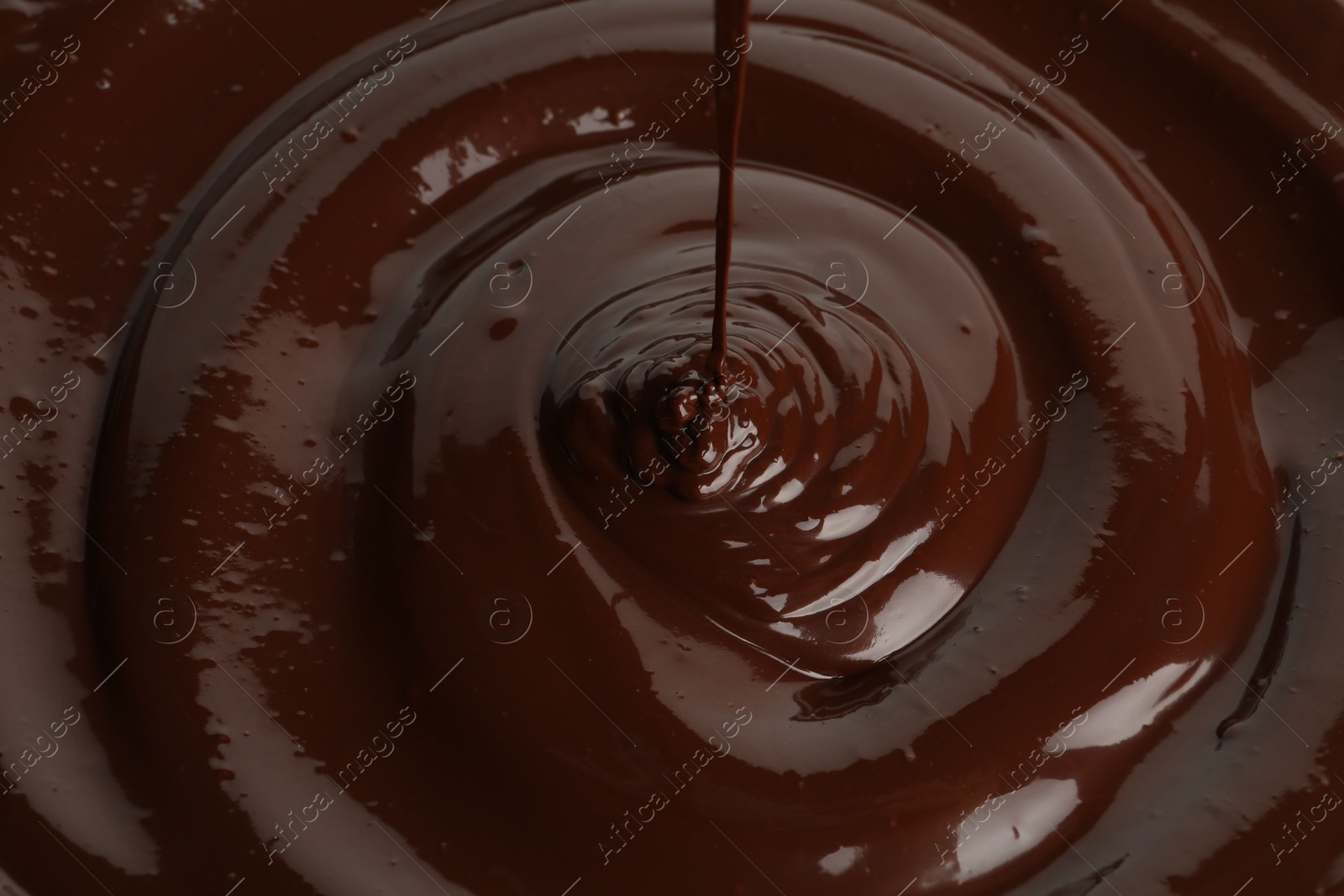 Photo of Closeup view of pouring delicious melted chocolate