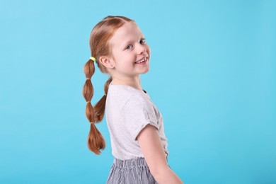 Photo of Portrait of smiling girl on light blue background