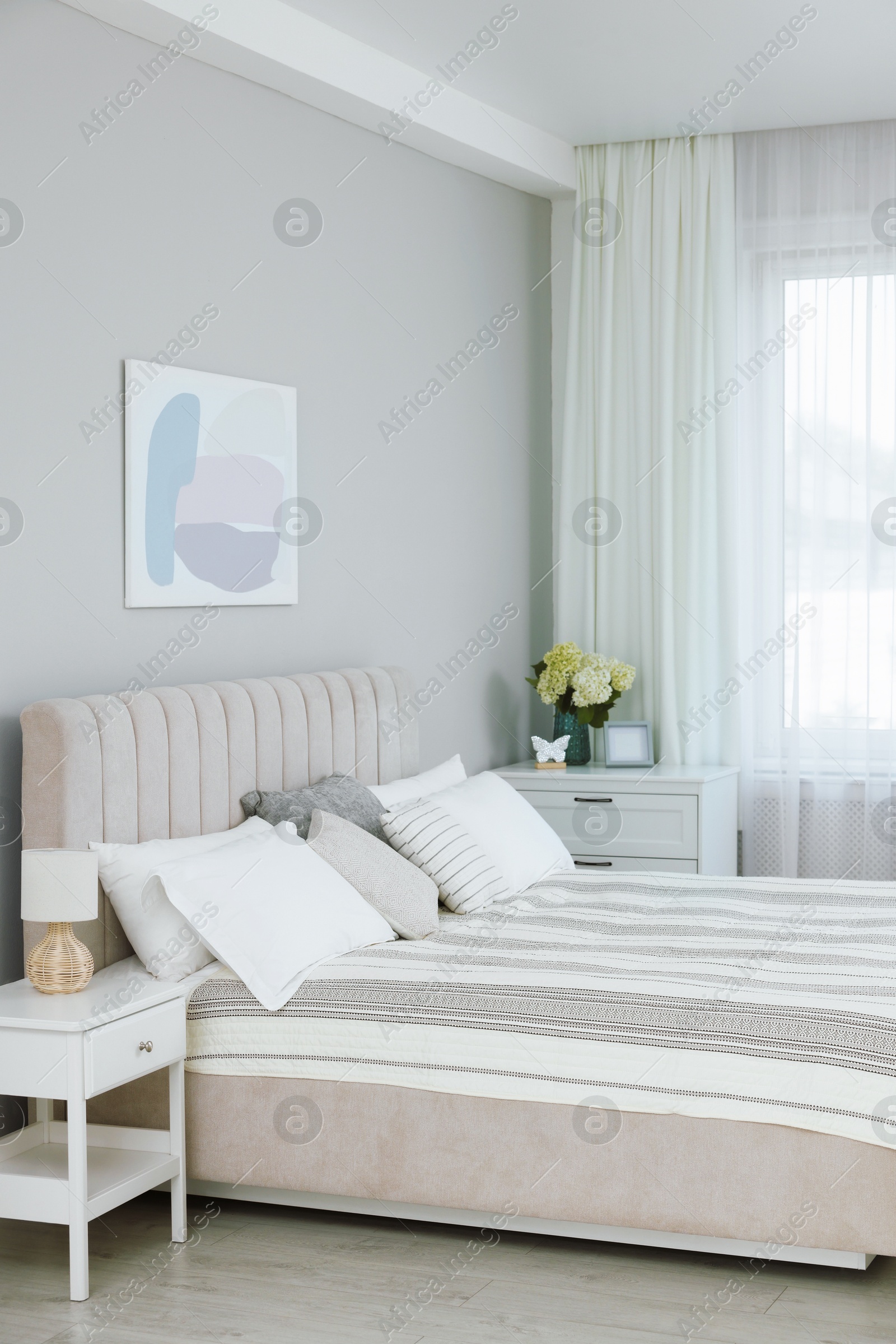 Photo of Large bed, nightstand, chest of drawers and window with curtains in bedroom. Interior design