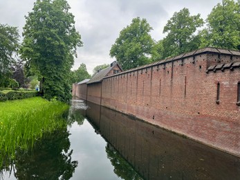 Photo of Picturesque view of castle, river and trees on spring day