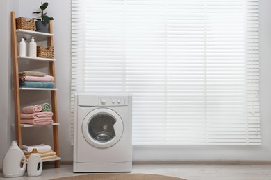 Washing machine, detergents, towels and shelving unit in laundry room