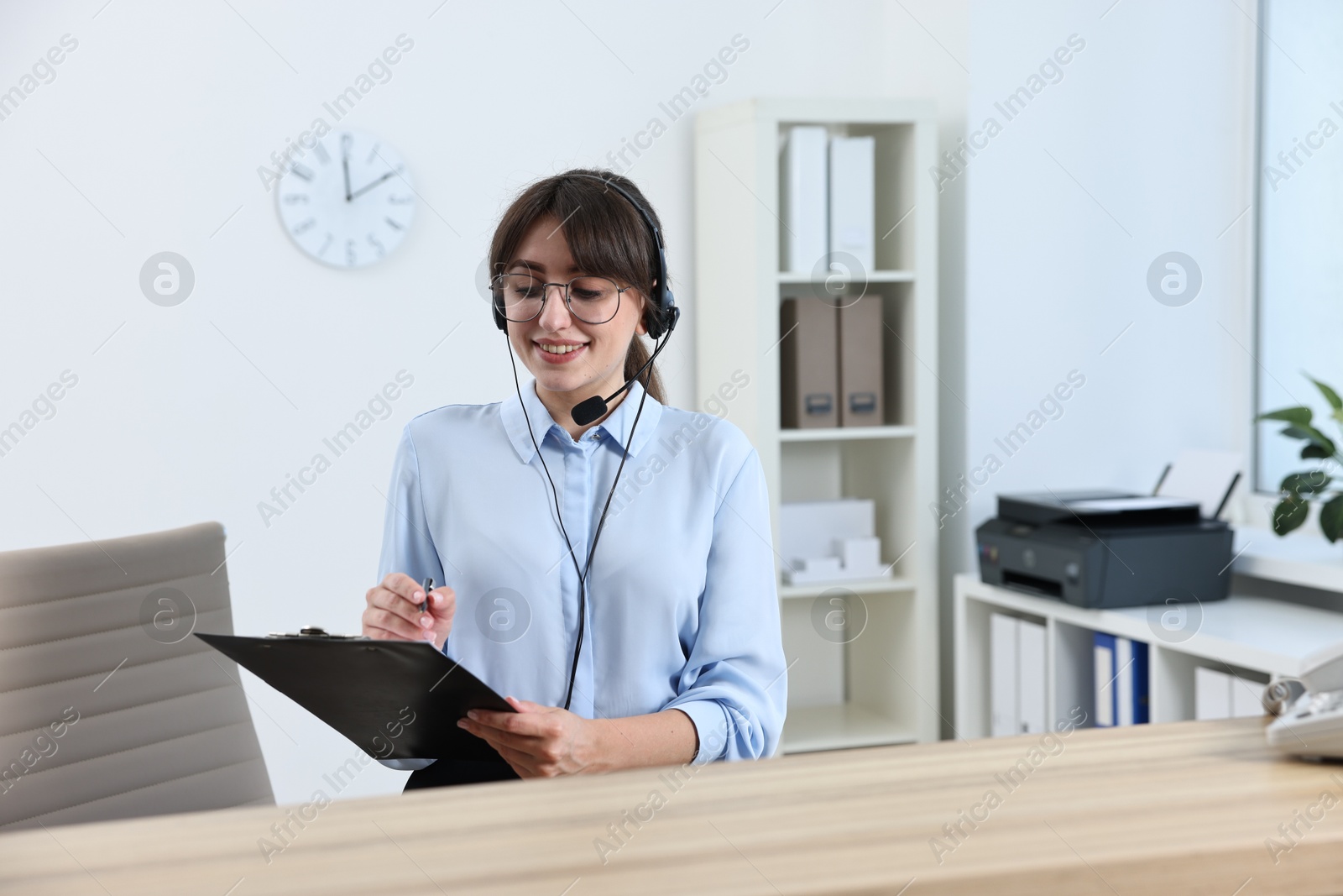 Photo of Professional receptionist working at wooden desk in office