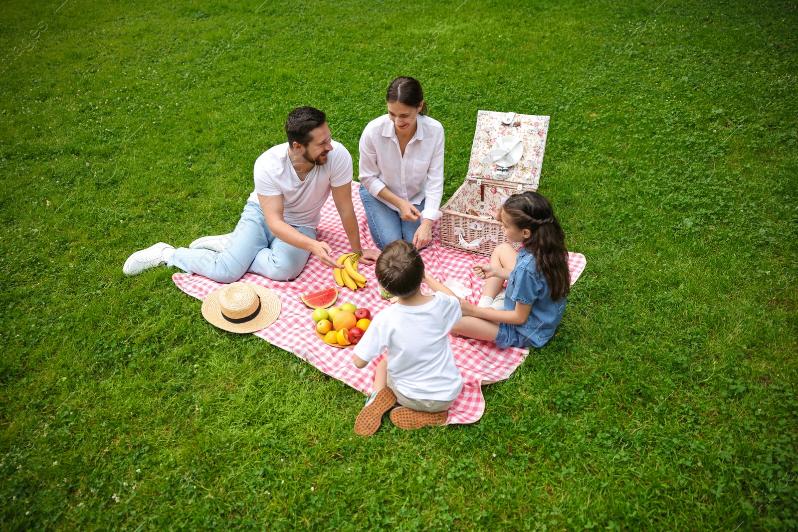 Photo of Family playing rock, paper and scissors during picnic outdoors