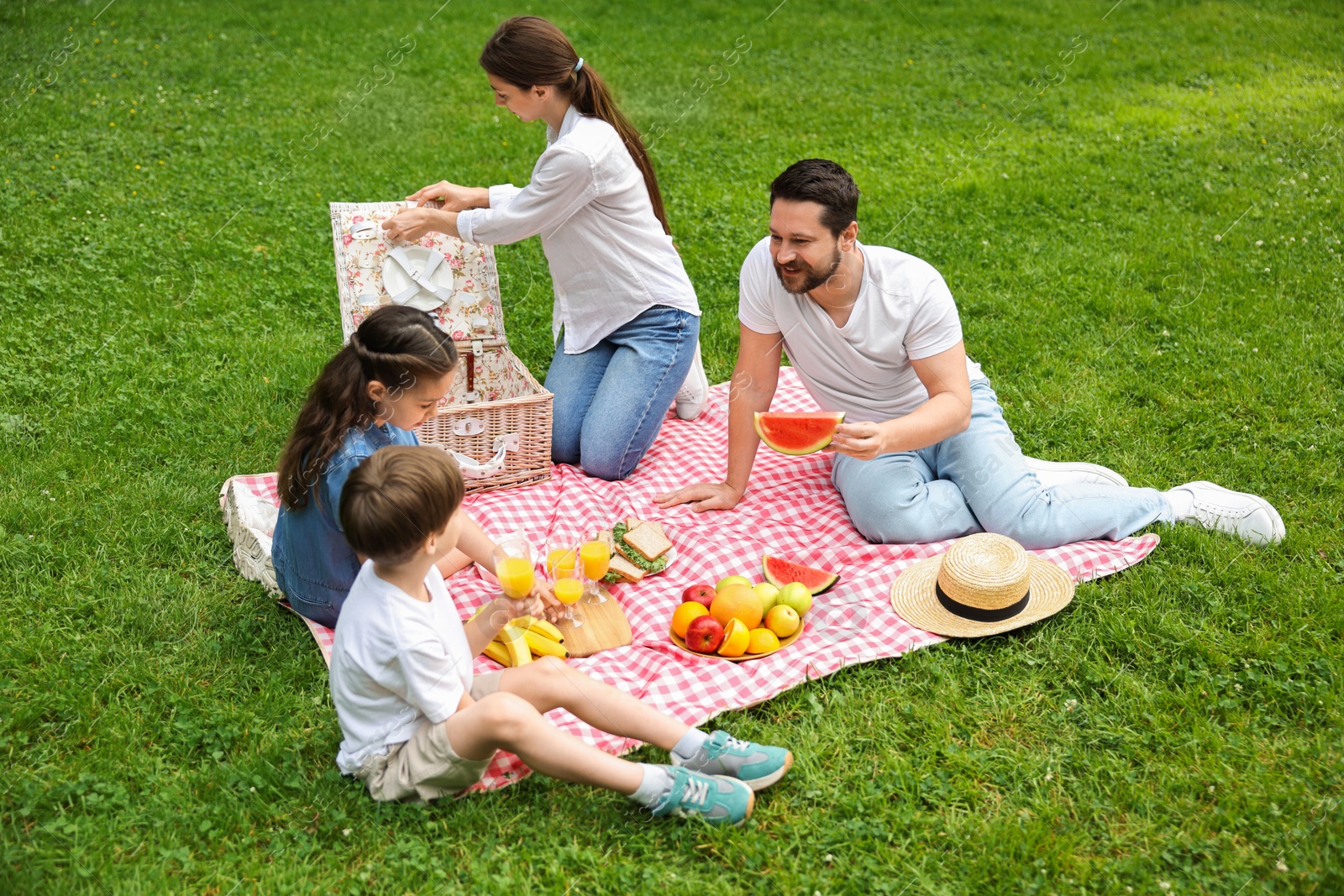 Photo of Happy family having picnic together in park