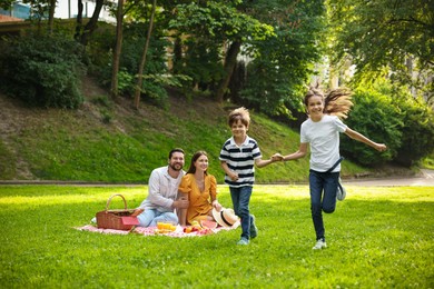 Photo of Happy children playing during family picnic outdoors