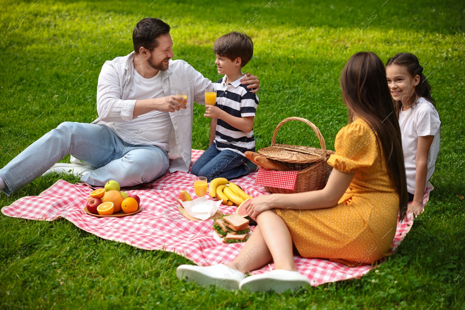 Photo of Happy family having picnic together in park