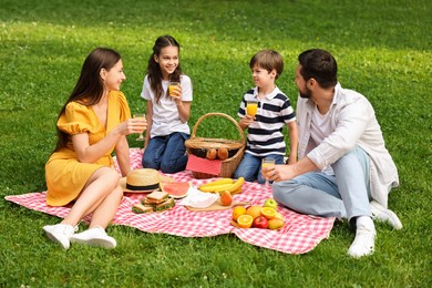 Photo of Family picnic. Parents and their children spending time together outdoors
