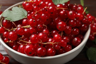 Photo of Fresh red currants in bowl on table, closeup