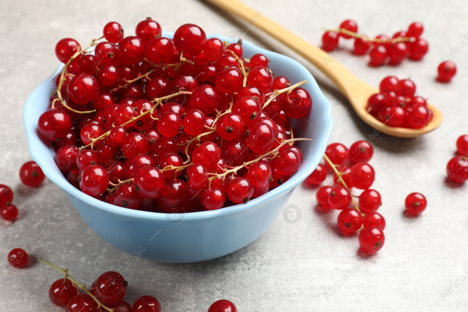 Photo of Fresh red currants on light grey table, closeup