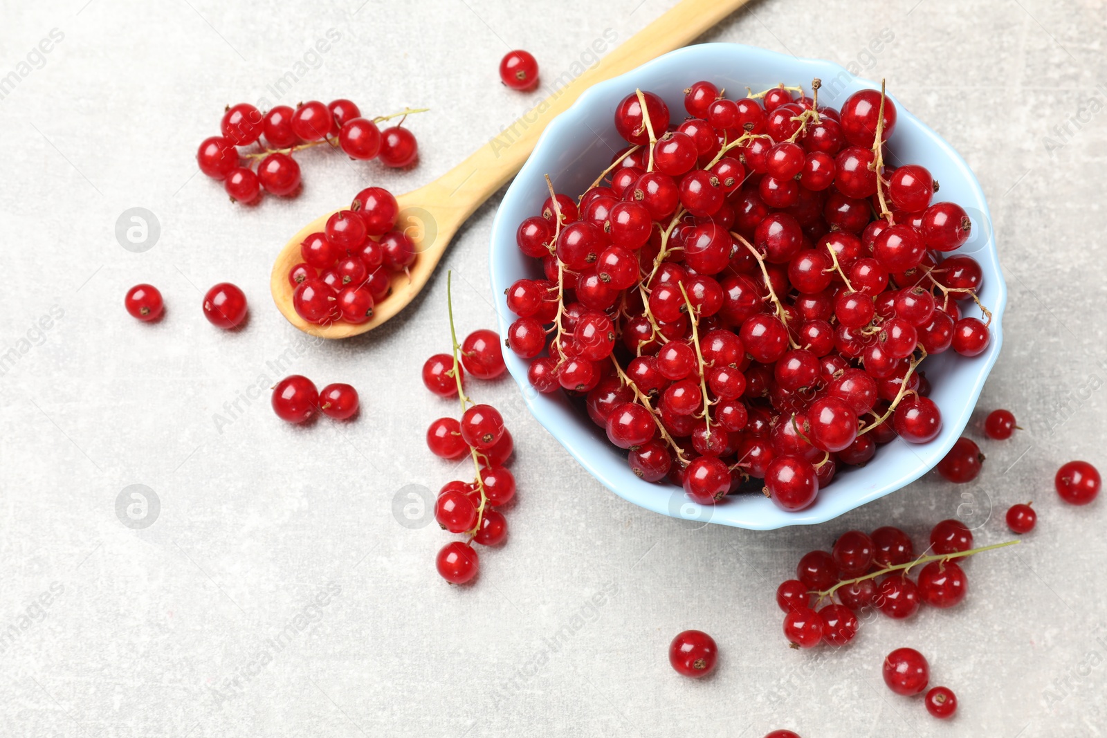 Photo of Fresh red currants on light grey table, flat lay