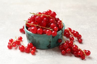 Photo of Fresh red currant in bowl on light table, closeup