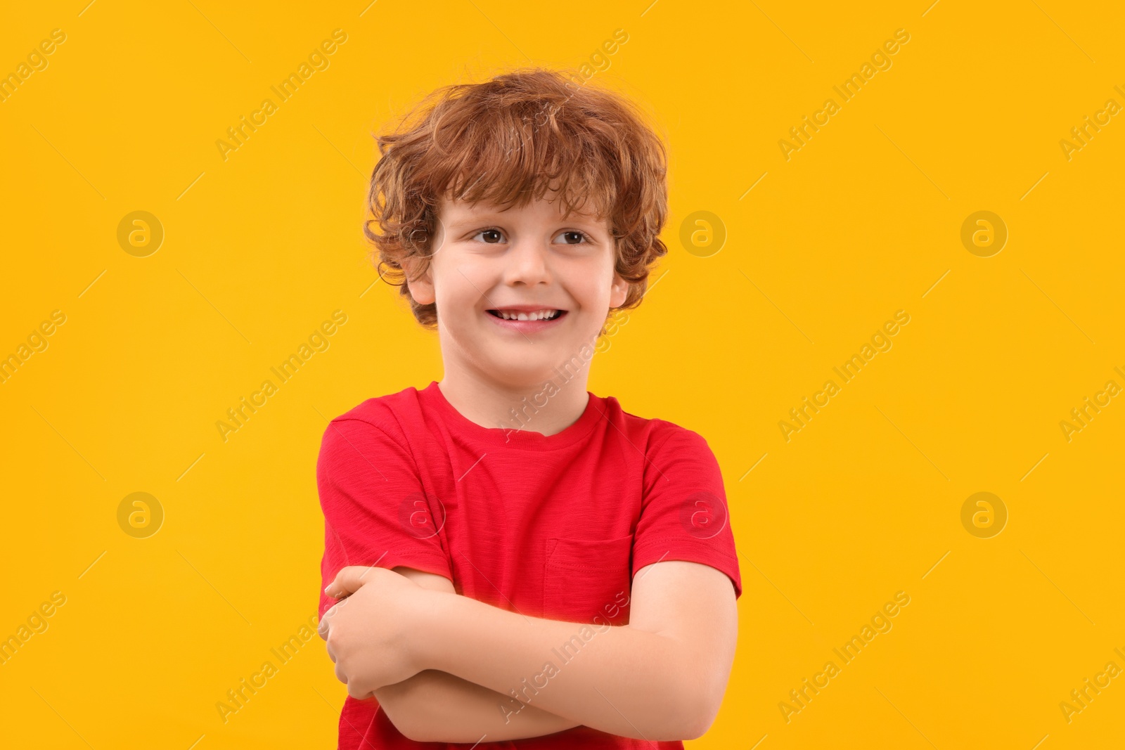 Photo of Portrait of cute little boy on orange background