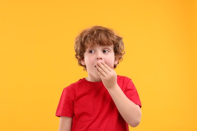 Photo of Portrait of emotional little boy on orange background