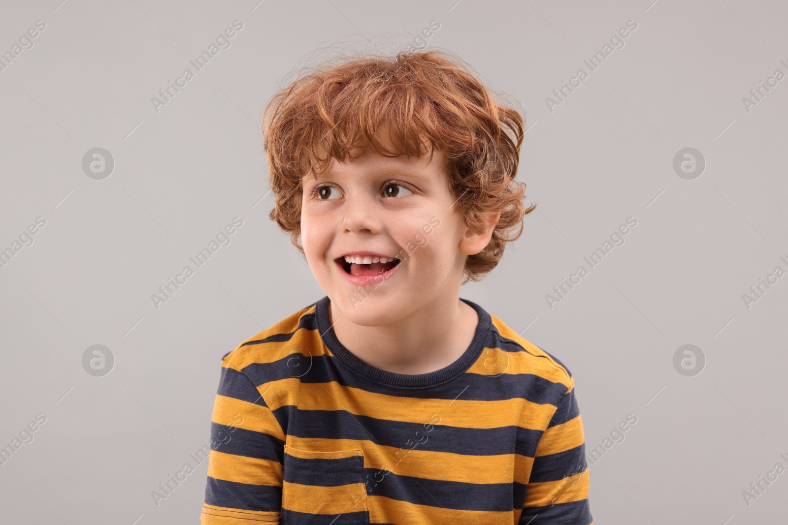 Photo of Portrait of cute little boy on grey background