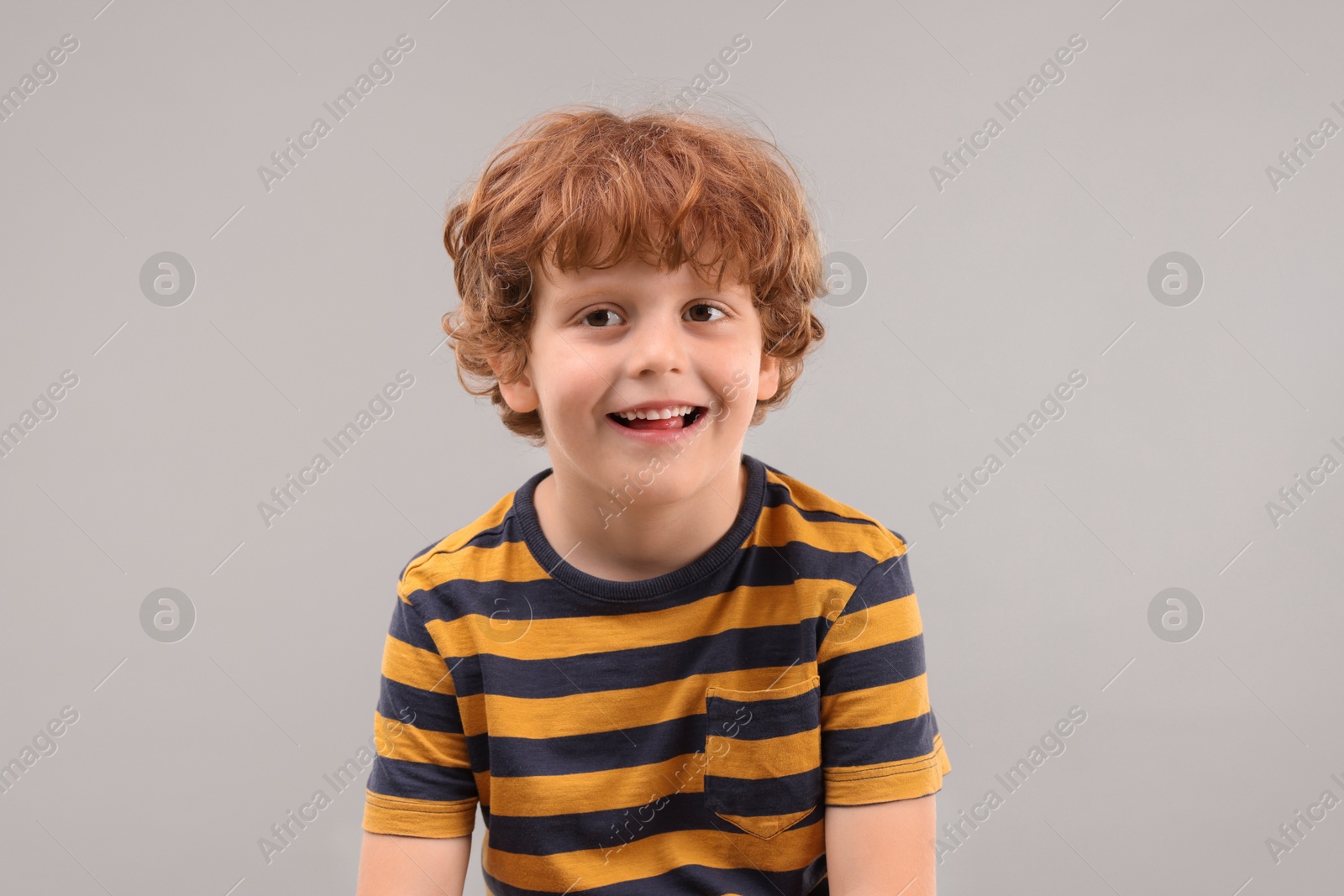 Photo of Portrait of cute little boy on grey background