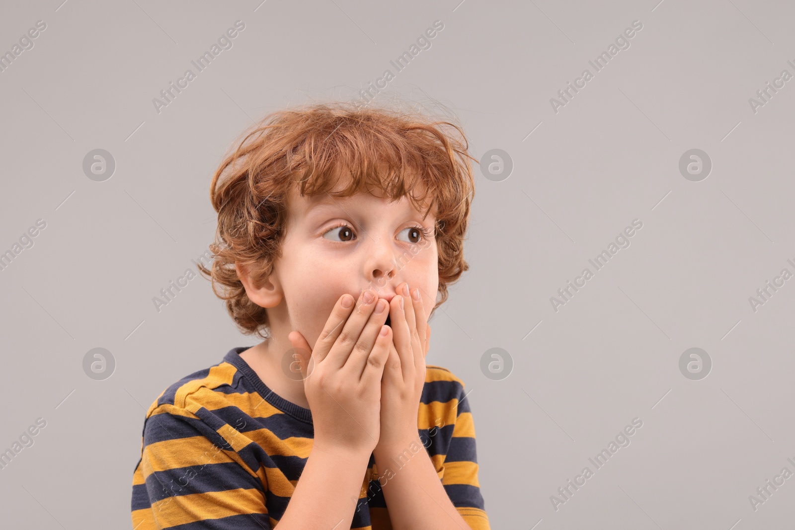 Photo of Portrait of cute little boy on grey background, space for text