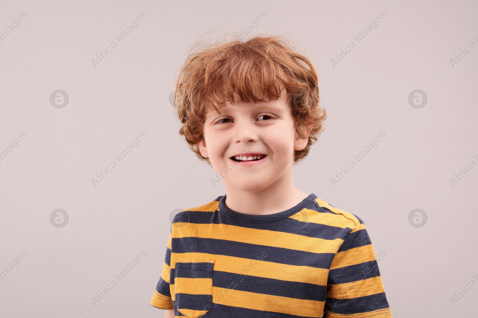 Photo of Portrait of cute little boy on grey background